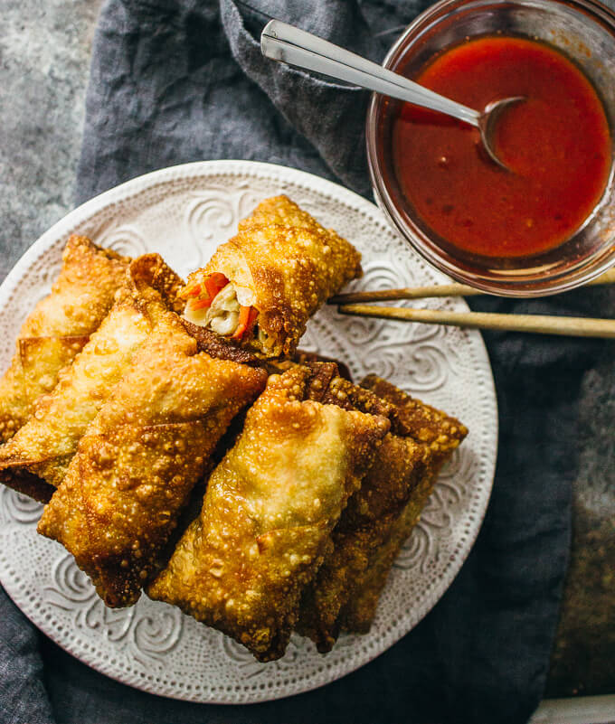overhead view of vegetable egg rolls with red sauce